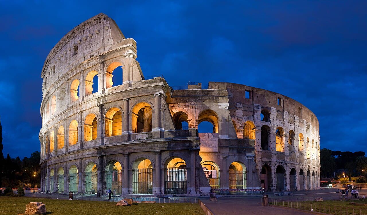 Illuminated exterior of the Colosseum in Rome at dusk